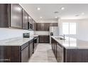 Bright kitchen showcasing stainless steel appliances, dark cabinets, granite countertops, and wood-look tile flooring at 18007 W Camino De Oro --, Surprise, AZ 85387