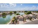 Stunning aerial view of a lakeside property with lush landscaping and serene waterfront at 1806 N 108Th Ave, Avondale, AZ 85392
