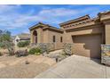 Desert home with stone accents, tile roof, two car garage and unique yard art at 26521 N 114Th Pl, Scottsdale, AZ 85255