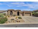 Single level home showcasing desert landscaping, mature trees, and a two car garage at 26521 N 114Th Pl, Scottsdale, AZ 85255