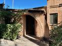 Inviting brick entryway showcasing an arched doorway and lush landscaping, exuding curb appeal at 3022 N 32Nd St # 40, Phoenix, AZ 85018