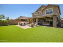 Expansive backyard featuring artificial grass, a covered patio and built-in BBQ area at 33275 N 132Nd Ave, Peoria, AZ 85383