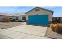 Inviting single-story home featuring a vibrant turquoise garage door and well-kept landscaping at 3417 W Abraham Ln, Phoenix, AZ 85027