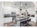 Modern kitchen featuring white cabinets, granite countertops, stainless steel appliances, and a center island with bar seating at 3855 S Mcqueen Rd # 24, Chandler, AZ 85286