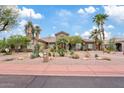 Attractive single-story home with desert landscaping, palm trees, and a well-maintained lawn at 4055 N Recker Rd # 82, Mesa, AZ 85215