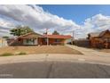 Charming single-story brick home with a well-manicured front yard, flag, and covered parking at 4117 W Sierra Vista Dr, Phoenix, AZ 85019