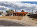 Charming single-story brick home with a well-manicured front yard, flag, and covered parking at 4117 W Sierra Vista Dr, Phoenix, AZ 85019