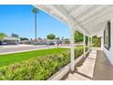 Inviting front porch with white columns, a lush green lawn, and a view of the neighborhood at 512 W Seldon Ln, Phoenix, AZ 85021