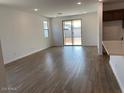 Open-concept living room features wood-look tile flooring, a sliding glass door, and recessed lighting at 7417 E Hackamore Ln, San Tan Valley, AZ 85143