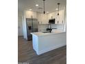 Modern kitchen features white cabinets, stainless steel appliances, and an eat-in island at 7637 E Akron St, Mesa, AZ 85207