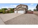 An angle view of the home's garage and driveway, accented by desert landscaping and a private gate at 824 E Chelsea Dr, San Tan Valley, AZ 85140