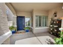 Inviting front porch with a blue door, window, and space for potted plants and outdoor decoration at 824 E Chelsea Dr, San Tan Valley, AZ 85140