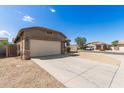 A single-Gathering home with a two-car garage, desert landscaping, and extended concrete driveway at 10245 W Parkway Dr, Tolleson, AZ 85353