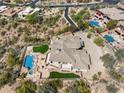Aerial view of home showing unique rock pool and landscaped yard surrounded by desert landscape at 12639 N 136Th St, Scottsdale, AZ 85259