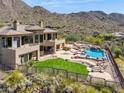 Custom home features lush green grass, swimming pool with waterfall feature, and desert landscape at 12639 N 136Th St, Scottsdale, AZ 85259