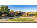 Inviting front yard with manicured landscaping, circular driveway, mature trees, and attractive exterior at 14022 W Hope Dr, Surprise, AZ 85379