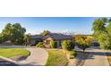 Inviting home with a circular driveway, lush landscaping, mature trees and 3-car garage at 14022 W Hope Dr, Surprise, AZ 85379