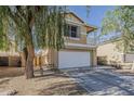 Two-story home with a balcony, a two-car garage, and desert landscaping at 14874 W Laurel Ln, Surprise, AZ 85379