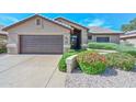 Attractive single-story home featuring lush landscaping, a concrete driveway, and a two-car garage at 15035 W Indianola Ave, Goodyear, AZ 85395