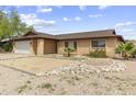 Traditional brick home with desert landscaping and a two-car garage at 15619 N 58Th Ave, Glendale, AZ 85306