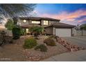 Two-story home featuring desert landscaping as the sun sets at 15834 W Port Au Prince Ln, Surprise, AZ 85379