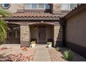 Covered front porch with decorative stone pillars and attractive front door at 15834 W Port Au Prince Ln, Surprise, AZ 85379