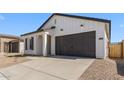 This home features a two car garage, stylish modern farmhouse design, and a clean driveway at 16575 N Lunar St, Maricopa, AZ 85138