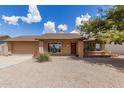 Charming single-story home with a well-manicured gravel yard and a lush tree providing shade and curb appeal at 1750 W Mohawk Ln, Phoenix, AZ 85027