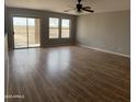 Open-concept living room with wood-look floors and sliding glass doors at 1876 N Parkside Ln, Casa Grande, AZ 85122
