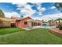 Beautiful backyard featuring an artificial lawn, pool, covered patio, and green seating area at 19645 N 3Rd Ave, Phoenix, AZ 85027