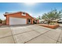 Single-story home with a two-car garage, complemented by mature landscaping and a spacious driveway at 19645 N 3Rd Ave, Phoenix, AZ 85027