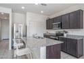 Well-lit kitchen features a spacious granite island with seating and modern appliances at 21882 N 260Th Ln, Buckeye, AZ 85396