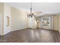 Bright living room with dark wood-look floors, modern lighting, and a neutral color palette at 2523 W Running Deer Trl, Phoenix, AZ 85085