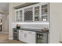 Custom wet bar featuring wine storage, glass cabinets, and beverage refrigerators, perfect for entertaining at 2664 E Ebony Dr, Chandler, AZ 85286
