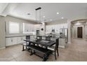 Bright kitchen boasts white cabinetry, stainless steel appliances, a large island, and an elegant dining table at 2664 E Ebony Dr, Chandler, AZ 85286
