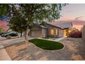 A beautifully landscaped home featuring a green lawn, desert landscaping, and a two-car garage at 3922 N 125Th Dr, Avondale, AZ 85392
