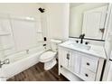 Clean bathroom with a shower-tub combo and updated vanity with solid surface counters at 42418 W Sunland Dr, Maricopa, AZ 85138