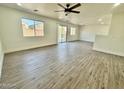 Bright living room featuring wood-style flooring and multiple windows for natural light at 42418 W Sunland Dr, Maricopa, AZ 85138