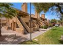 Exterior view of the condo with desert landscaping, terracotta roofing, and private stairways leading to units at 4901 S Calle Los Cerros Dr # 219, Tempe, AZ 85282