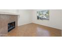 Open living area with tile flooring, a fireplace, bright natural light, and neutral walls, perfect for relaxing at 6811 W Aire Libre Ave, Peoria, AZ 85382