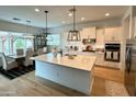 Modern kitchen featuring white cabinetry, stainless appliances, stone countertops and pendant lighting at 7158 E Posada Ave, Mesa, AZ 85212