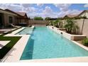 Sparkling pool with waterfall feature, artificial grass, and lounge chairs at 7158 E Posada Ave, Mesa, AZ 85212