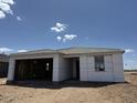 A partially finished home under construction shows a charming one story with an open garage and blue sky at 7707 W Avenida Del Rey --, Peoria, AZ 85383