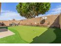 Backyard boasts a putting green, patio area and block wall at 7822 W Mcrae Way, Glendale, AZ 85308