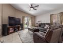 Cozy living room with plush leather seating and a ceiling fan at 7822 W Mcrae Way, Glendale, AZ 85308