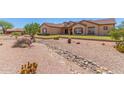Charming home with desert landscaping, rock accents, and a well-maintained front yard at 9625 W Prospector Dr, Queen Creek, AZ 85144