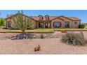 Charming single-story home featuring desert landscaping, a red front door, and dormer windows at 9625 W Prospector Dr, Queen Creek, AZ 85144