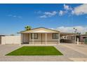 Single story home shows a covered front porch, gravel landscaping, and a covered carport on a sunny day at 1064 S 97Th St, Mesa, AZ 85208