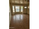 Bright living room with ceramic tile flooring and large bay window bringing in lots of natural light at 124 S Cottonwood St, Chandler, AZ 85225