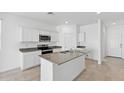 Contemporary kitchen features a large island with a sink, granite countertops, and stainless steel appliances at 1331 W Hess Ave, Coolidge, AZ 85128